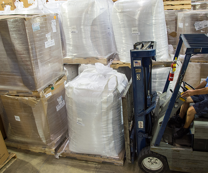 Warehouse worker loading crates with with a forklift